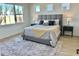 Spacious main bedroom with large windows and gray upholstered bed at 8324 Golden Beach Ct, Parrish, FL 34219