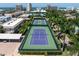 Aerial view of tennis courts surrounded by lush landscaping and palm trees at 5924 Midnight Pass Rd # 209, Sarasota, FL 34242