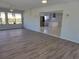 Living room with open concept to kitchen and wood-look floors at 1732 Boca Raton Ct, Punta Gorda, FL 33950