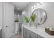 Modern bathroom with a glass-enclosed shower, sleek vanity, and stylish round mirror at 3028 Sky Blue Cv, Bradenton, FL 34211