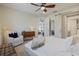 Serene bedroom with soft natural light, a ceiling fan, and cozy seating area at 3028 Sky Blue Cv, Bradenton, FL 34211