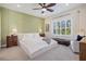 Cozy bedroom featuring natural light, a ceiling fan, and stylish olive green accent wall at 3028 Sky Blue Cv, Bradenton, FL 34211