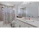 Bright bathroom featuring a marble countertop, white cabinets, and a shower with a floral curtain at 4918 Fallcrest Cir, Sarasota, FL 34233