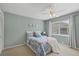 Cozy bedroom with a ceiling fan, plush bed, and a window with plantation blinds at 4918 Fallcrest Cir, Sarasota, FL 34233