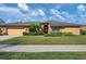 Single-story home featuring an attached garage, brick accents, and mature landscaping at 4918 Fallcrest Cir, Sarasota, FL 34233