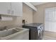 Functional laundry room with a modern washer and dryer, and utility sink at 4918 Fallcrest Cir, Sarasota, FL 34233