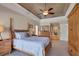 A spacious main bedroom with a tray ceiling, ceiling fan, and light wood furniture at 4918 Fallcrest Cir, Sarasota, FL 34233