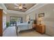 Serene main bedroom with tray ceiling, bedside tables, and sliding door to the lanai at 4918 Fallcrest Cir, Sarasota, FL 34233