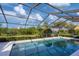 A serene screened-in pool area with clear blue water and lush landscaping at 4918 Fallcrest Cir, Sarasota, FL 34233