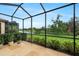 Relaxing screened-in lanai with lush green backyard and tranquil water views at 340 Cedar Falls Dr, Apollo Beach, FL 33572