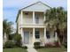 Two-story house with light yellow siding, gray accents, and a front porch at 4707 Woodbrook Dr, Sarasota, FL 34243