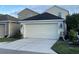 Attached garage with white door and landscaping at 4707 Woodbrook Dr, Sarasota, FL 34243