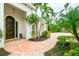 Front entry with a charming arched wooden door and a brick walkway at 1954 Datura St, Sarasota, FL 34239