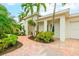 Bright, inviting exterior with a paved walkway, lush landscaping, and palm trees at 1954 Datura St, Sarasota, FL 34239
