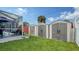 Large backyard with storage sheds, lush lawn, and screened pool area at 1080 Piedmont Rd, Venice, FL 34293