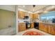 Cozy kitchen with wood cabinets, stainless steel appliances, and a red rug at 1080 Piedmont Rd, Venice, FL 34293