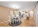 Bright dining area with white table and chairs, view into updated kitchen at 2300 Stickney Point Rd Rd # 104, Sarasota, FL 34231