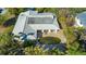 Aerial view of the property showcasing a metal roof and a private pool nestled within lush landscaping at 435 Partridge Cir, Sarasota, FL 34236