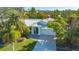 Captivating aerial view of a single-story home with a metal roof surrounded by lush palm trees and tropical foliage at 435 Partridge Cir, Sarasota, FL 34236