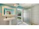 Stylish bathroom featuring a pedestal sink and a walk-in shower with direct access to the outdoor pool area at 435 Partridge Cir, Sarasota, FL 34236