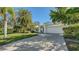 Inviting single-story home with a manicured lawn, a white garage door, and a paved brick driveway at 435 Partridge Cir, Sarasota, FL 34236