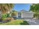 Charming single-story home with vibrant blue double-door entry, manicured landscaping, and a convenient two-car garage at 435 Partridge Cir, Sarasota, FL 34236