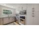 Contemporary kitchen with stainless steel appliances, sleek cabinets, and a window with backyard views at 435 Partridge Cir, Sarasota, FL 34236