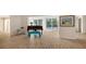 Bright living room with a piano, wood floors, and sliding glass doors to the pool area at 435 Partridge Cir, Sarasota, FL 34236