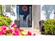 Dark-stained front door accented by planters and flowers at 8123 8Th Nw Ter, Bradenton, FL 34209