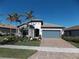 One-story house with stone accents, gray garage door, and palm trees at 13005 Rinella St, Venice, FL 34293