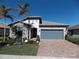 One-story home with gray roof, stone accents, and landscaped yard at 13005 Rinella St, Venice, FL 34293