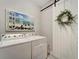 Laundry room with white washer and dryer and barn door at 13005 Rinella St, Venice, FL 34293