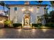 Stunning home with a grand entrance and beautiful landscaping at dusk at 65 Lighthouse Point Dr, Longboat Key, FL 34228