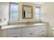 Bathroom with granite countertop, white cabinets, and a large mirror at 6725 Roxbury Dr, Sarasota, FL 34231