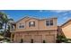 Tan three-story townhome with three-car garage and palm trees at 3671 Parkridge Cir # 8-201, Sarasota, FL 34243