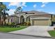 Tan one-story house with a two-car garage and lush landscaping at 13122 50Th E Ct, Parrish, FL 34219