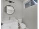 Small bathroom with white vanity, toilet and a round mirror at 14065 Paris Ln, Port Charlotte, FL 33981