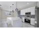 Modern kitchen with white cabinets, large island, and stainless steel appliances at 14065 Paris Ln, Port Charlotte, FL 33981