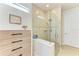 Bright bathroom featuring a glass enclosed shower with tile surround, a built-in bench and modern fixtures at 16920 Pelham Pl, Bradenton, FL 34202