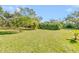 Large grassy backyard with mature trees and lush vegetation at 2910 49Th St, Sarasota, FL 34234