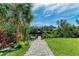 Landscaped backyard with a walkway leading to a canal at 901 30Th E Ct, Bradenton, FL 34208