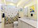 Bathroom with a shower, white vanity, and floral shower curtain at 9908 Carnoustie Pl, Bradenton, FL 34211