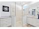 Bathroom with a walk-in shower, double vanity, and tiled walls at 9908 Carnoustie Pl, Bradenton, FL 34211