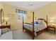 Bright bedroom with a wooden post bed, window with shutters, and a dresser at 9908 Carnoustie Pl, Bradenton, FL 34211