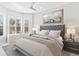 Serene bedroom with a gray upholstered headboard and bay window at 9908 Carnoustie Pl, Bradenton, FL 34211