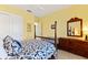 Bedroom with a wooden post bed, dresser, and window with shutters at 9908 Carnoustie Pl, Bradenton, FL 34211