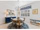 Elegant dining room with a round table, chandelier, and blue accents at 9908 Carnoustie Pl, Bradenton, FL 34211