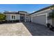 Single-story home with gray exterior, paver driveway, and garage at 9908 Carnoustie Pl, Bradenton, FL 34211