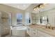 Elegant bathroom with double vanity, soaking tub, and walk-in shower at 10643 Old Grove Cir, Bradenton, FL 34212