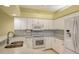 White kitchen with granite countertops and stainless steel sink at 10643 Old Grove Cir, Bradenton, FL 34212